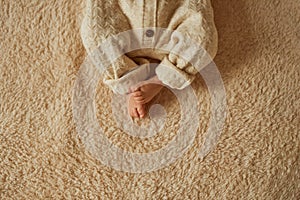 feet of a newborn, the baby is dressed in a warm knitted suit