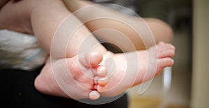 Feet of newborn baby in the hand of mother