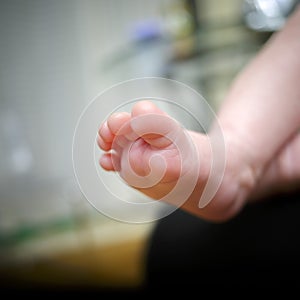 Feet of newborn baby in the hand of mother