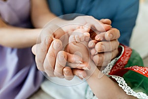 Feet of a newborn baby in the hands of parents. Happy Family oncept. Mum and Dad hug their baby`s legs