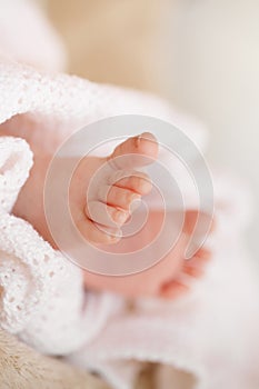 Feet of a newborn baby in the mother's gentle hands.