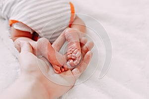 feet of newborn baby in mother& x27;s hand