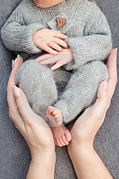 Feet of a newborn baby, toes in the hands of mom and dad, hands and nails of a child, the first days of life after birth.