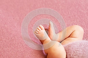 Feet of the newborn girl baby, fingers on the foot, maternal care, love and family hugs, tenderness