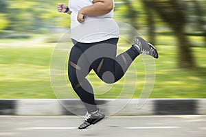 Feet of obese woman sprinting on the road