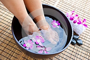Feet in orchid spa bowl