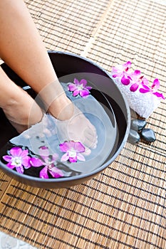 Feet in orchid spa bowl