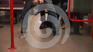 Feet of a passenger walking on a train car. The passenger chooses a seat.