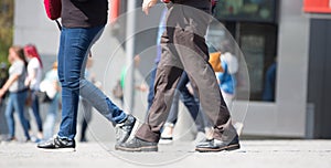 Feet of pedestrians walking on the crosswalk in Oxford street, London. Modern life, travel and shopping concept. UK, London