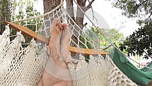 Feet of a person resting in a hammock