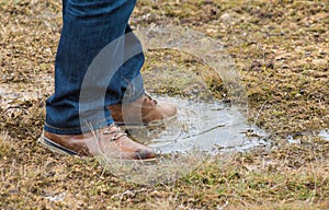 Feet of a person standing in a puddle of water