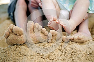 Feet playing with sand on the beach. Conceptual image shot