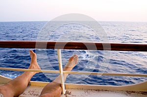 Feet relaxing by balcony of caribbean cruise ship