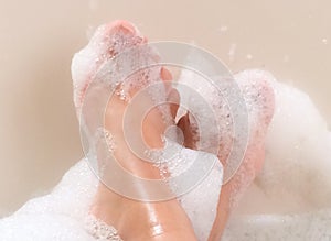 Feet relaxing in soapy bubble bath tub photo