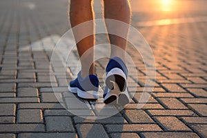 Feet on the road arrow in the rays of the setting sun