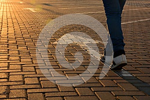 Forward movement. Feet on the road with arrows in the rays of the setting sun photo