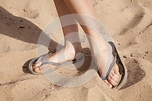 Feet in the sand with flipflops