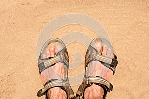 Feet in sandals on sand