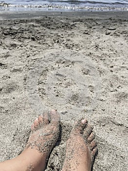 Feet on a sandy beach in summer