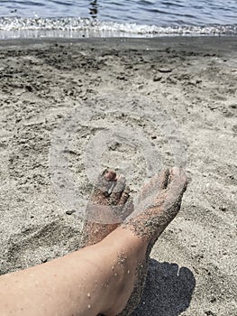 Feet on a sandy beach in summer