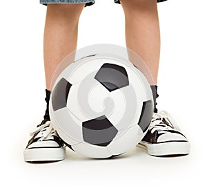 Feet shod in sneakers and soccer ball