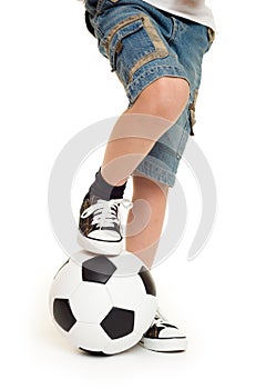 Feet shod in sneakers and soccer ball