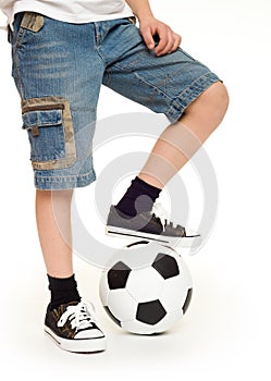 Feet shod in sneakers and soccer ball