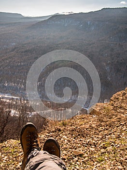 Feet in shoes lay on a rock