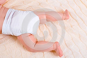 Feet of a six months old baby wearing diapers