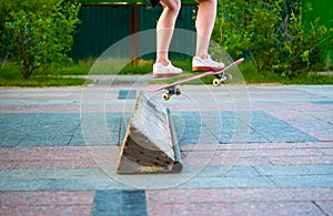 Feet of skateboarder perform stunts in city Park, street youth sports,