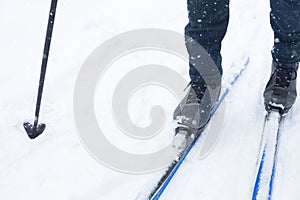 Feet of a skier in ski boots on cross-country skis. Walking in the snow, winter sports, healthy lifestyle. Close-up, copyspace
