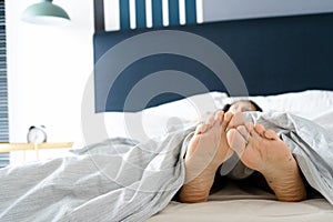 Feet of a sleeping girl in bed in the morning. Spy photo