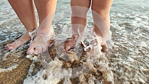 Feet small baby  on the sand with water wave of the sea beach