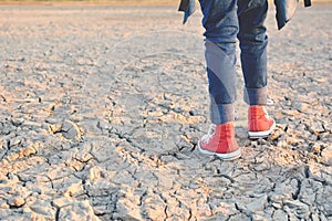 Feet sneaker on crack dry ground