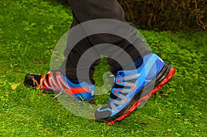 Feet in sneakers on green grass