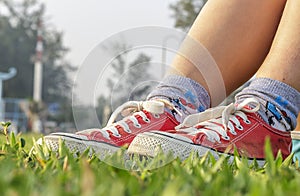 Feet in sneakers in green grass