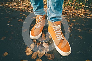 Feet sneakers walking on fall leaves Outdoor