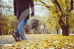 Feet sneakers walking on fall leaves