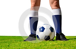 Feet of soccer player with ball on football field.