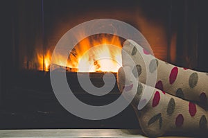 Feet in socks of all the family warming by cozy fire