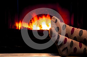 Feet in socks of all the family warming by cozy fire