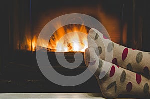 Feet in socks of all the family warming by cozy fire