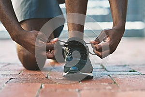 Feet, sport and shoes tie on pavement with person and athlete for running and jog. Shoelace, wellness, fitness with