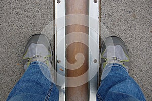 Feet stand on opposite sides of the Prime Meridian.
