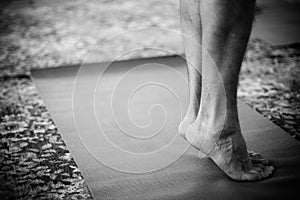 Feet standing on yoga mat