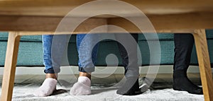 Feet sticking out under a sofa table