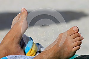 Feet of sunbather on beach