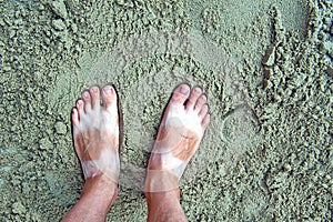 Feet with tanlines from sandals in sand