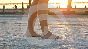 The feet of a teenager walk along white salty crust on salt lake extraction factory Sivash in Kherson region, Ukraine