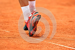 Feet of a Tennis Player Jumping to Serve on a Clay Tennis Court